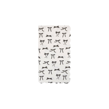 pack of 24 white scalloped dinner napkins with black scattered bow designs. Sold at Confetti my party and fast shipping Canada wide.