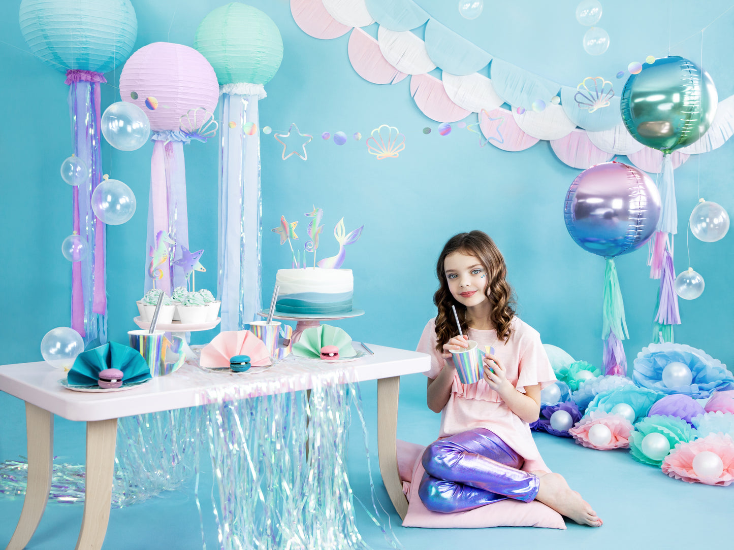 Mermaid party setup with iridescent seashell plates, cups, and balloons in Toronto.