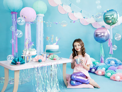 Mermaid party setup with iridescent seashell plates, cups, and balloons in Toronto.