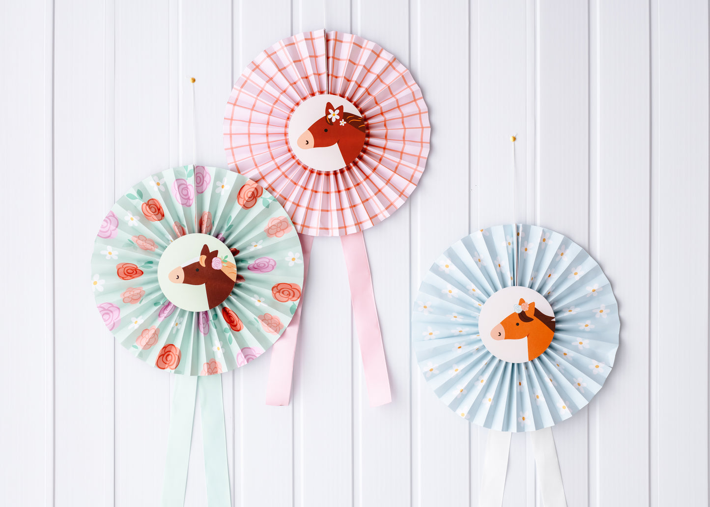 Pastel pony paper rosettes hanging on a wall backdrop, approx. 35 cm each, sold at Confetti My Party Toronto