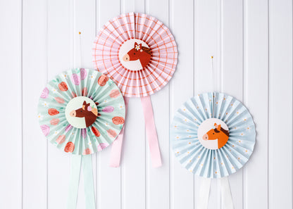 Pastel pony paper rosettes hanging on a wall backdrop, approx. 35 cm each, sold at Confetti My Party Toronto