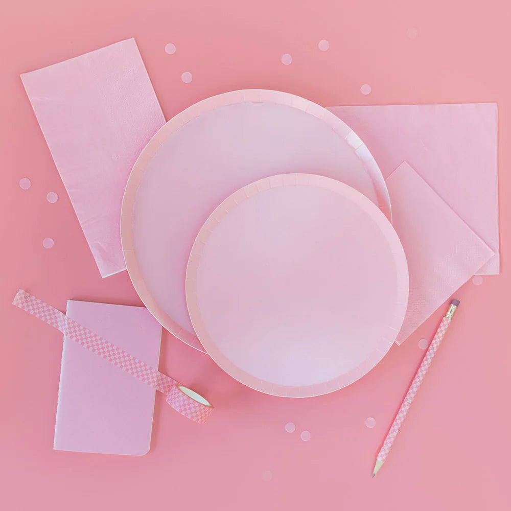 Flat lay of Shades Dinner Plates in amaranth pink with matching napkins, notebook, and pencil, available in Toronto and shipping across Canada