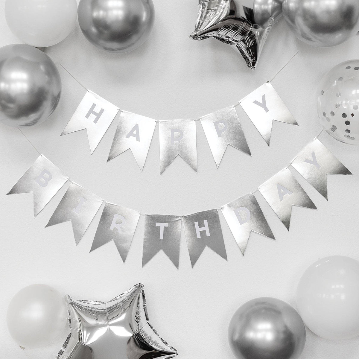 Silver 'Happy Birthday' banner with balloons on a white background