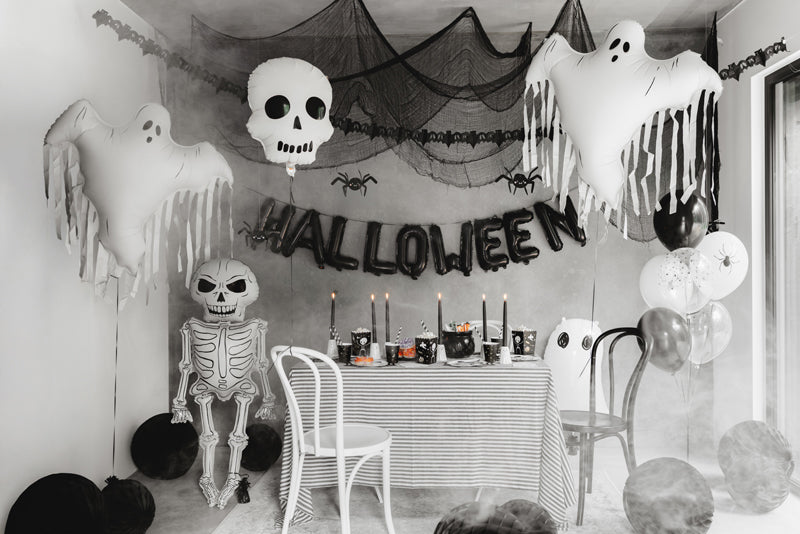 Halloween-themed room with decorations including ghosts, a skeleton, and balloons sold in Toronto at Confetti My Party.