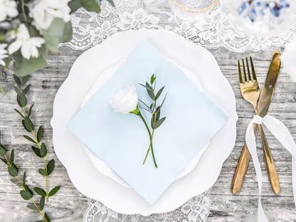 light blue napkin set up at dinner table setting