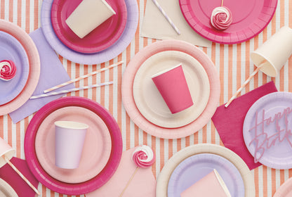 Colorful paper plates and cups on a striped background