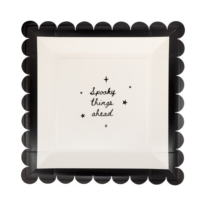 square paper plates with 'Spooky things ahead' text and black scalloped border on a white background