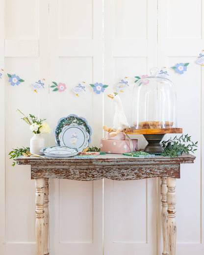 Spring goose banner styled above a pastel Easter party table