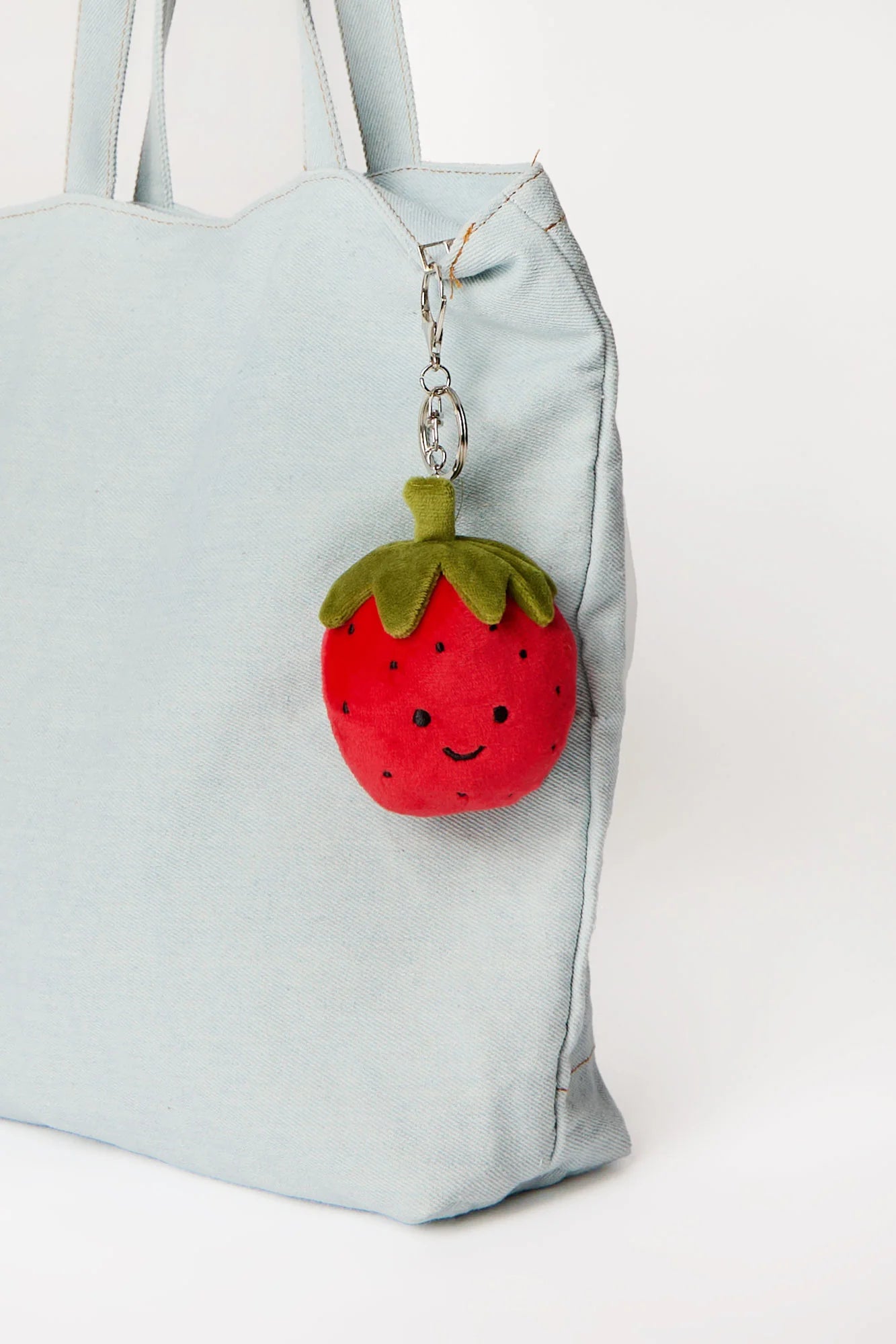 Strawberry plush keychain charm clipped onto tote bag available at our Toronto party shop