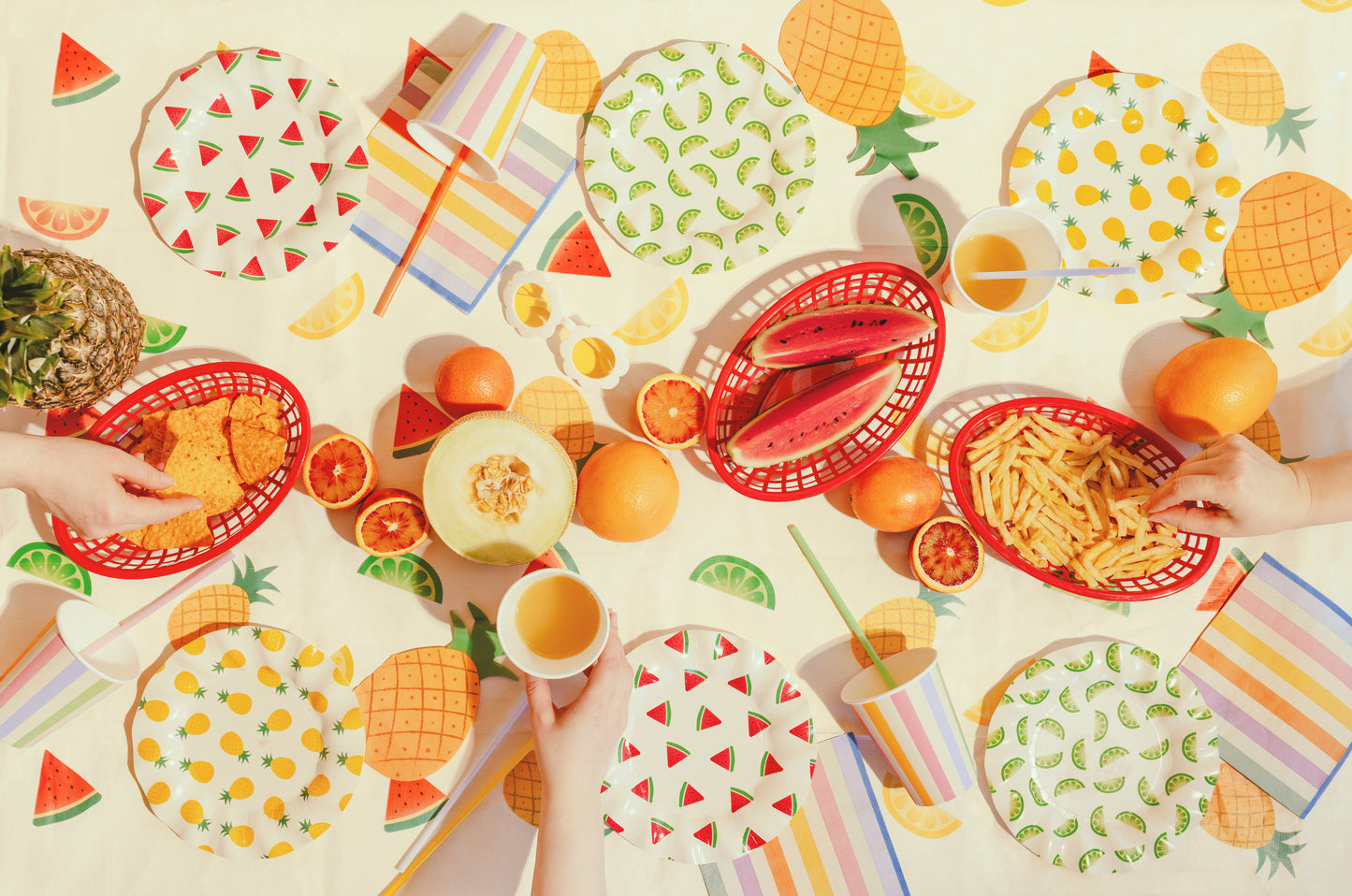 Summer party setup featuring fruit print tablecover with colourful coordinating tableware available at our Toronto party shop