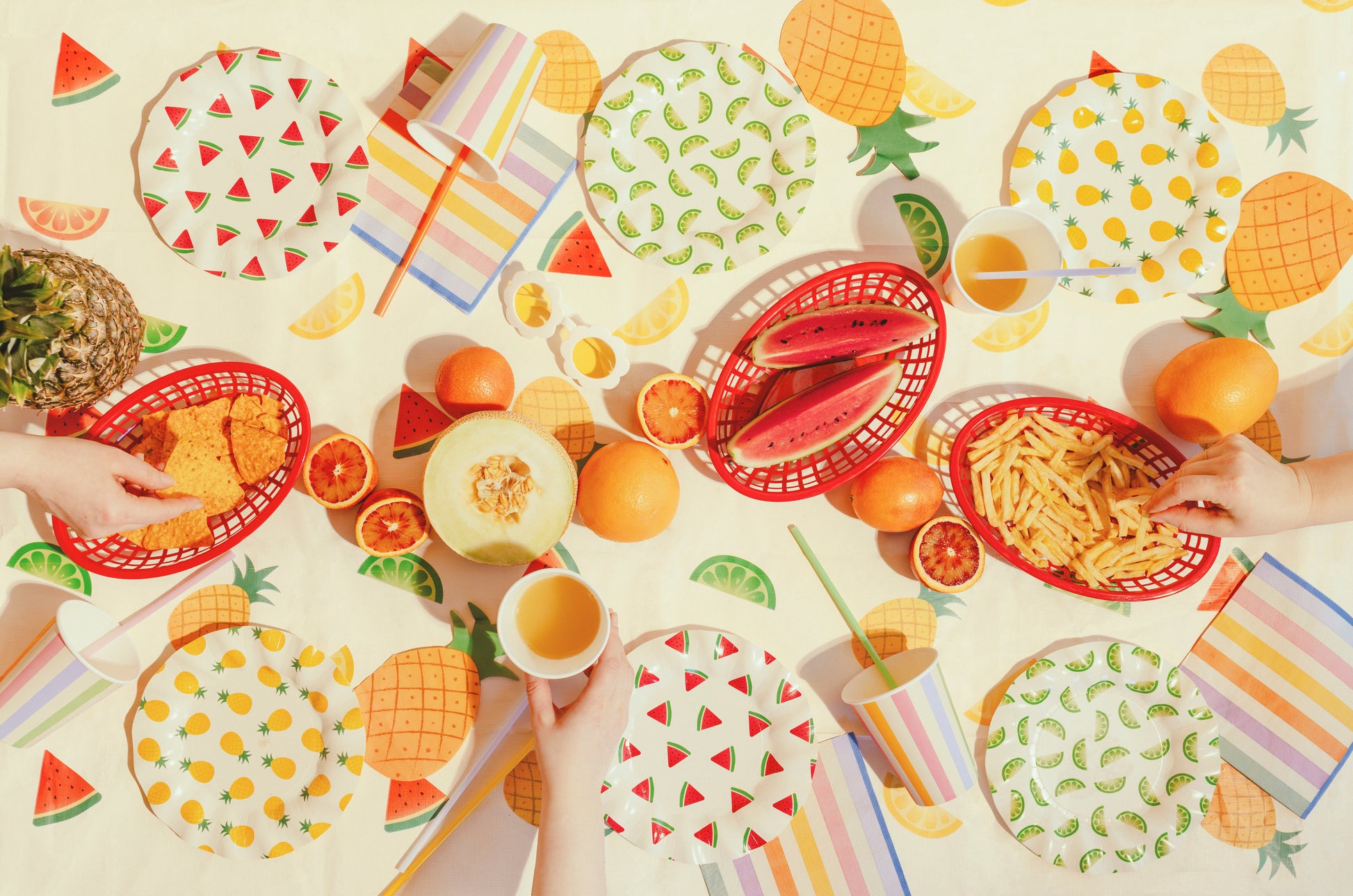 Summer party setup featuring fruit print tablecover with colourful coordinating tableware available at our Toronto party shop