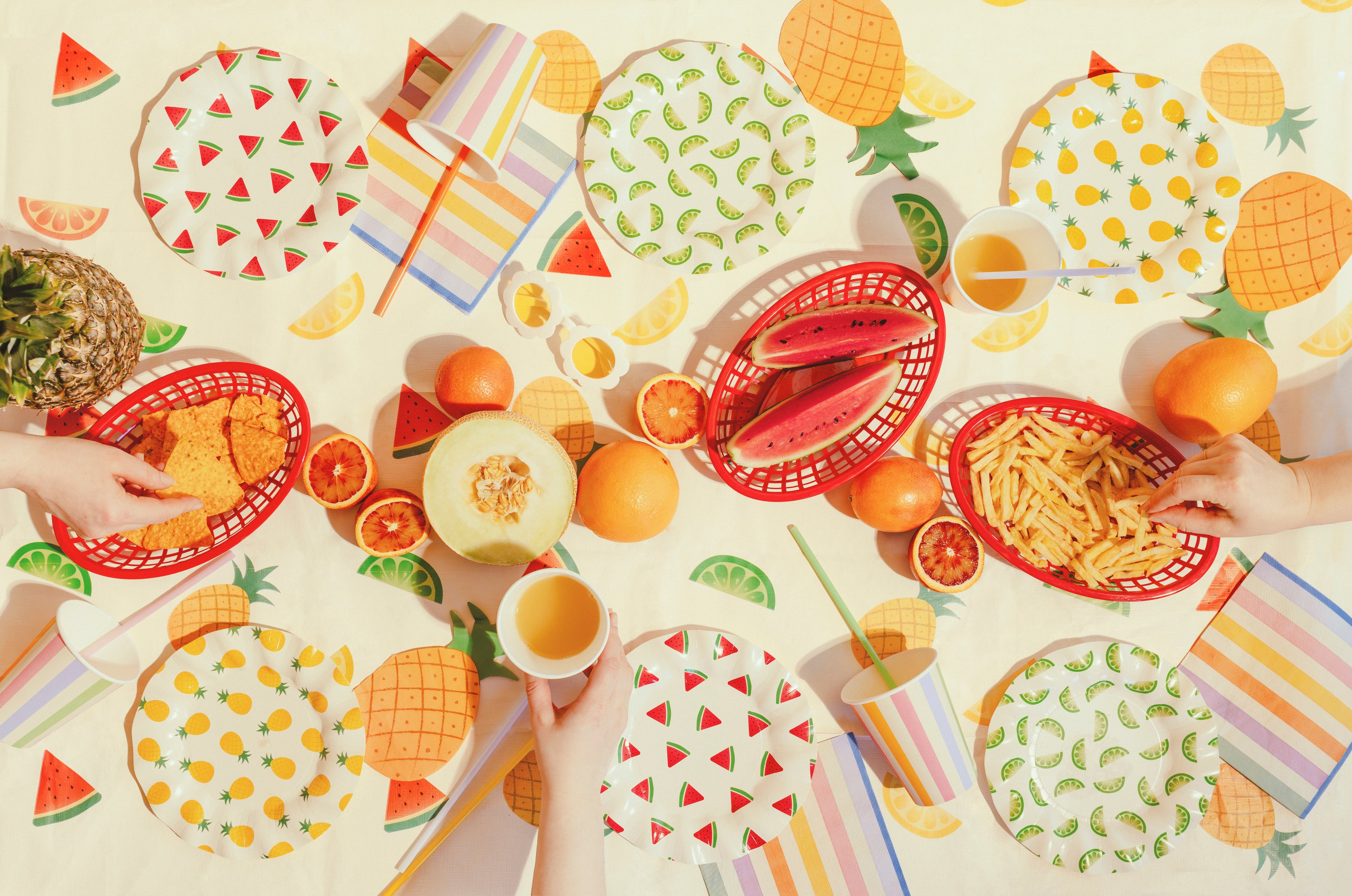 Summer party setup featuring fruit print tablecover with colourful coordinating tableware available at our Toronto party shop
