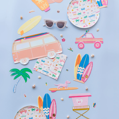 Flat lay of Surf’s Up surfboard guest napkins with tropical summer party decorations from our Toronto store.