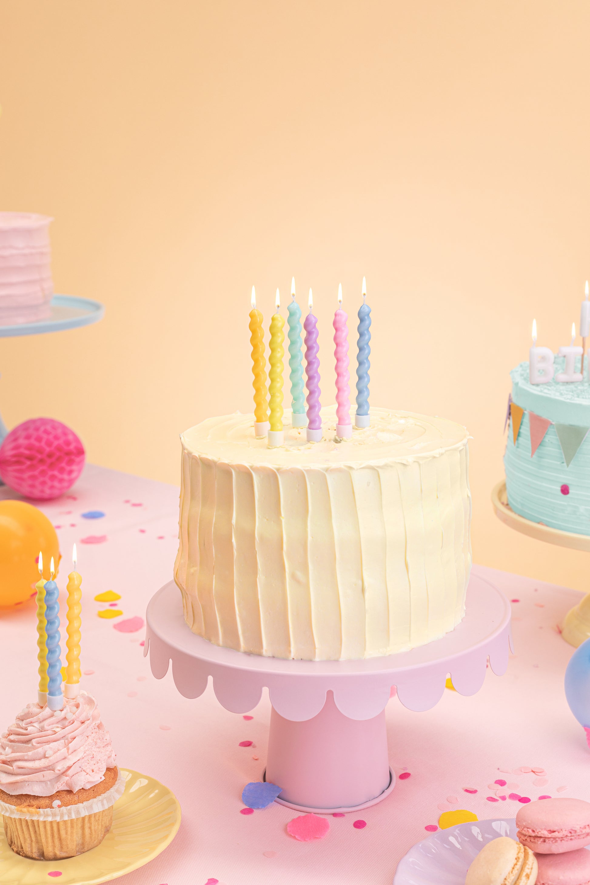 Pastel swirl candles displayed on a birthday cake in a colourful party setting, available in Toronto at Confetti My Party. Ships across Canada.