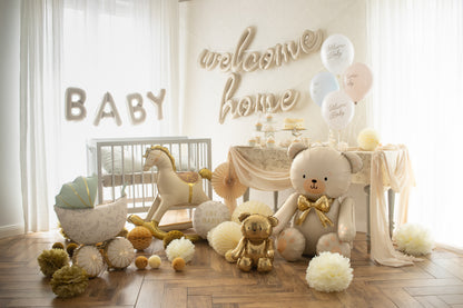 Beige teddy bear foil balloon with gold bow in nursery setup with party decor, shipping across Canada.
