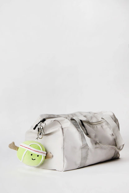 Tennis ball plush keychain charm clipped onto bag available in Toronto and shipping across Canada