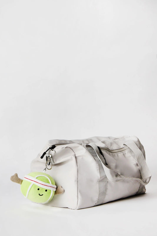 Tennis ball plush keychain charm clipped onto bag available in Toronto and shipping across Canada