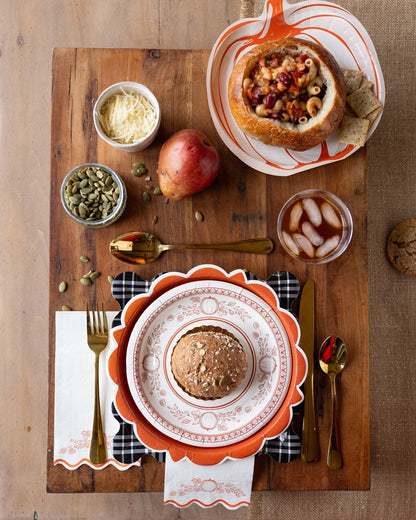 Dinner setting with bowls of food, a pomegranate, and cutlery on a wooden board thanksgiving theme.