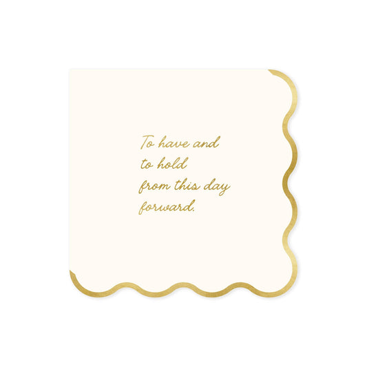 A square cream-colored napkin with scalloped gold edges and gold foil script text that reads, 'To have and to hold from this day forward.' on a solid white background.