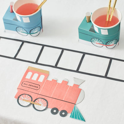  Train-themed table setup with train napkin, cups, and paper track decoration