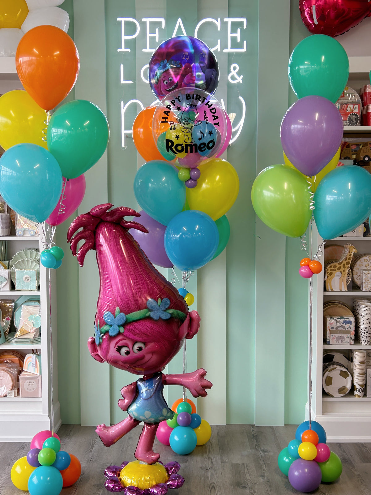 Trolls birthday balloon display featuring Poppy character balloon, personalized bubble balloon, colourful rainbow helium bouquets and decorative balloon bases in Toronto.