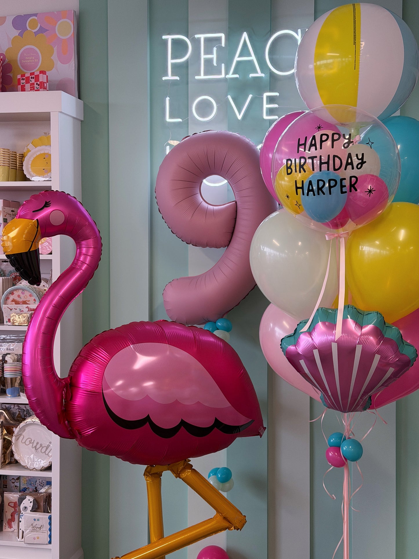 Tropical birthday balloon bundle with giant flamingo, pink matte number balloon, beach ball and colourful pool party balloons in Toronto.
