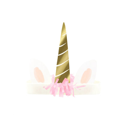 Gold unicorn horn with pink tassels on a white background