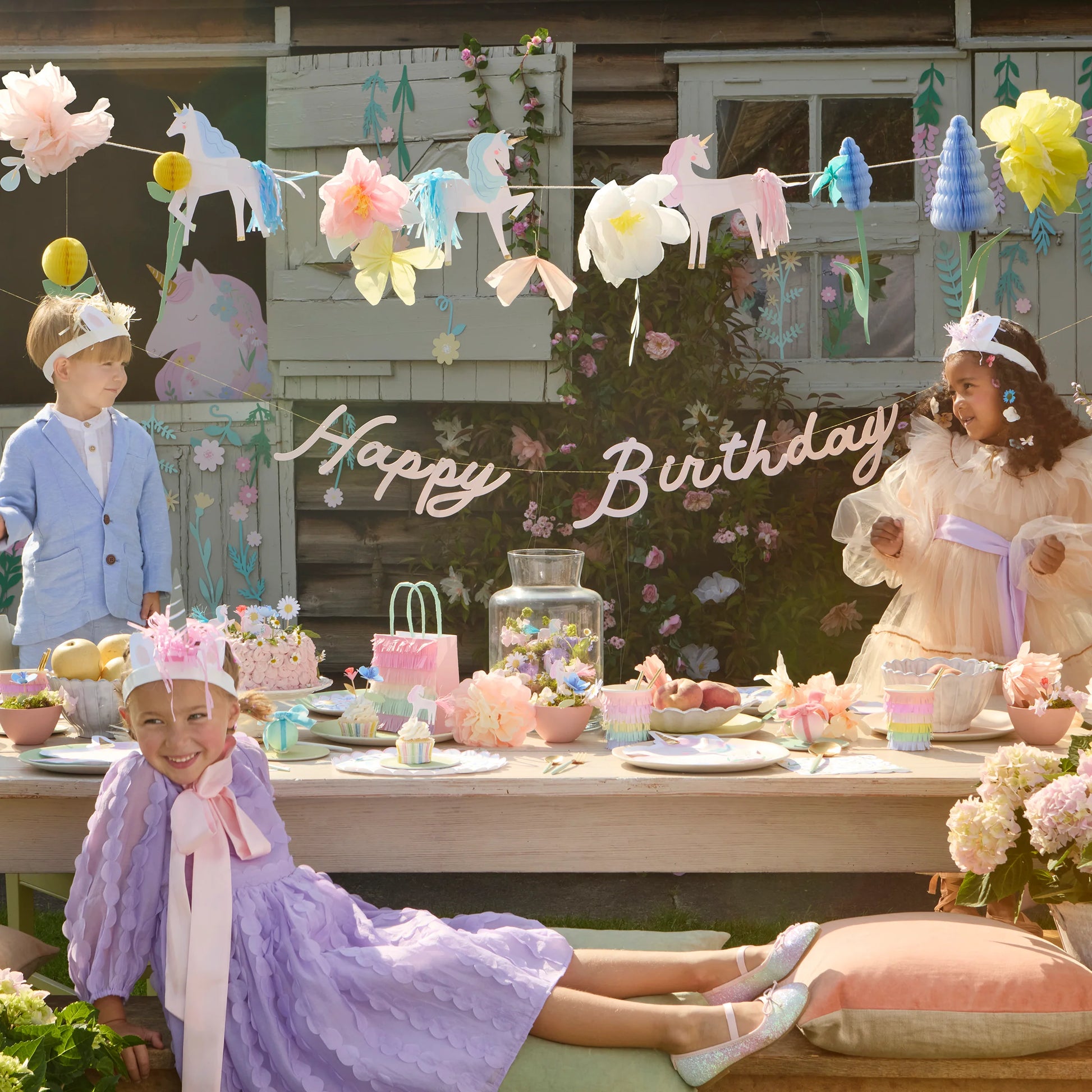 Children unicorn birthday party with decorations and a 'Happy Birthday' sign.