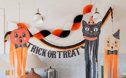 Halloween-themed decorations including a black cat, jack-o'-lantern, and trick-or-treat banner on a wall.