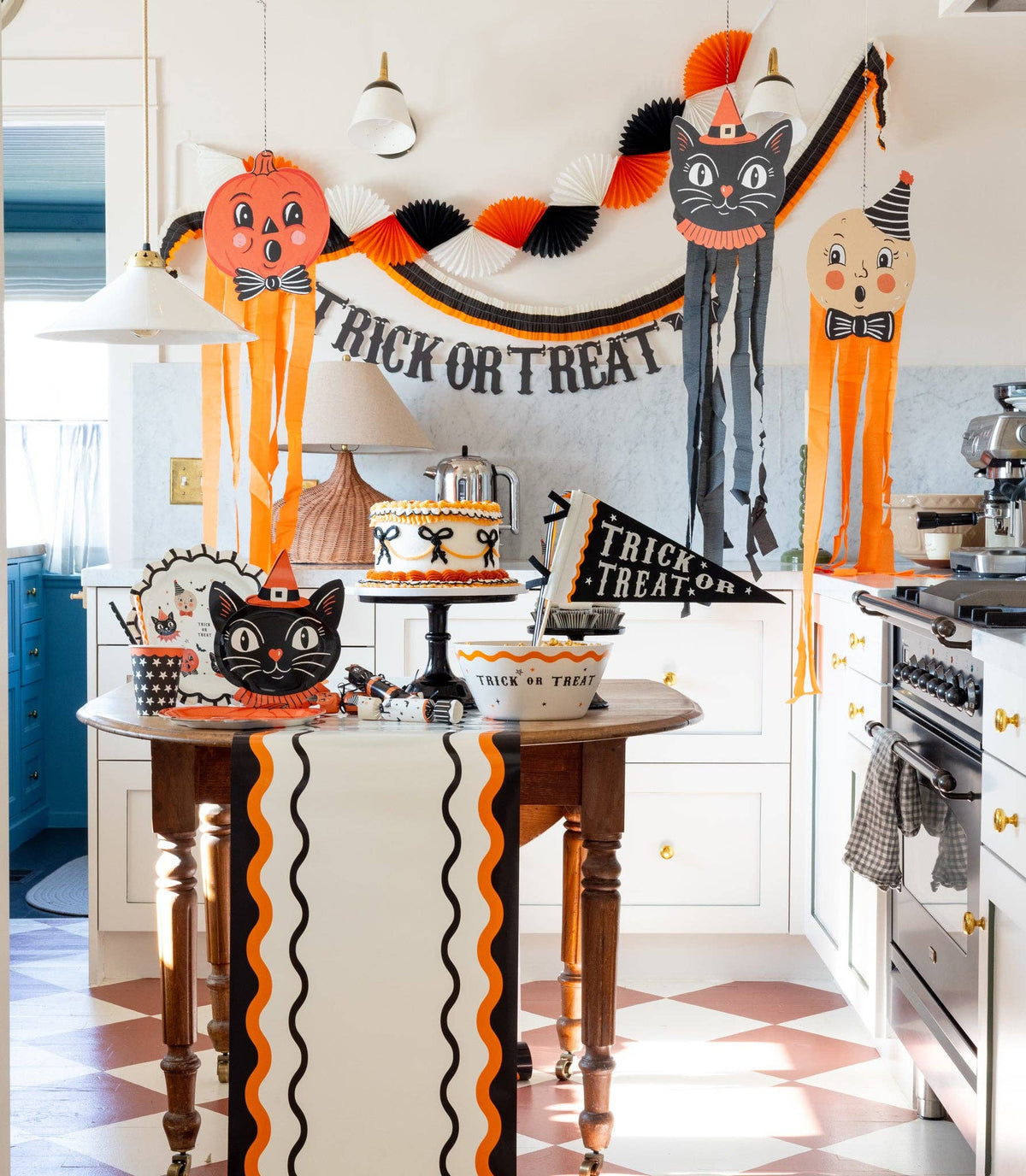 Halloween-themed kitchen with decorations, including a 'Trick or Treat' banner and cat-themed items.