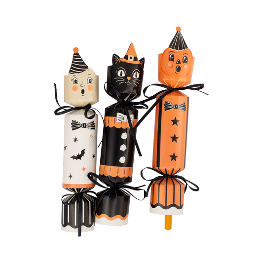 Three Halloween-themed crackers with cat, witch, and pencil designs on a white background.