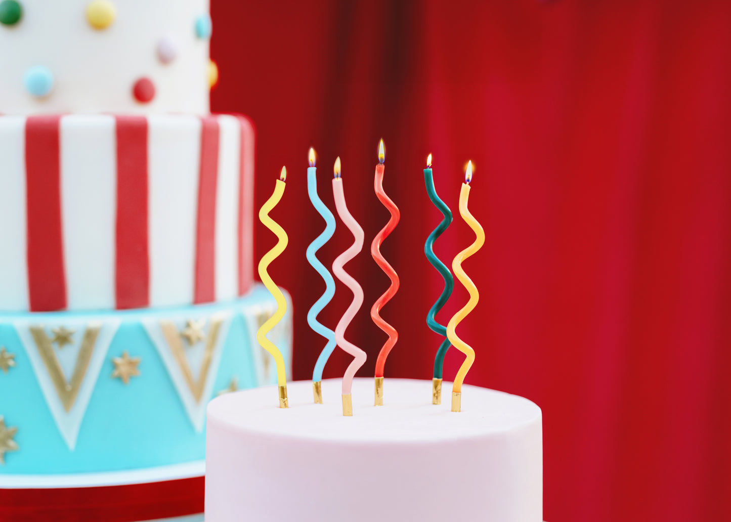 Colourful curl birthday candles styled on a modern birthday cake available in Toronto and shipping across Canada