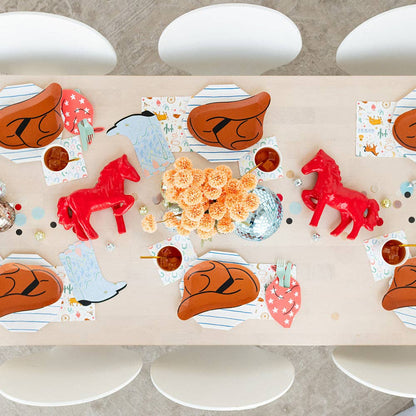 Western-themed kids’ party table setting with cowboy hat plates, boot napkins, and themed tableware.