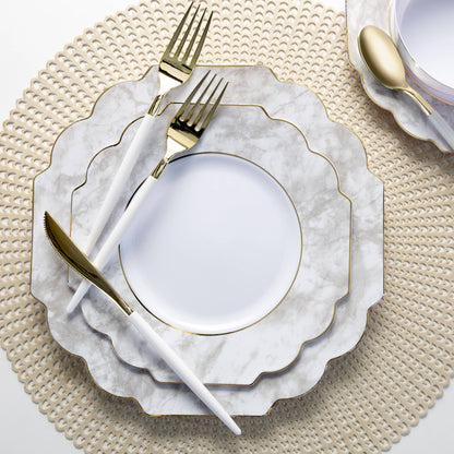 White and gold cutlery styled on marble plates and neutral placemats for an elegant Toronto party tablescape.