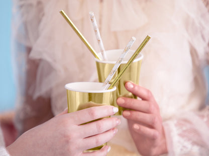 white and gold straws in cup