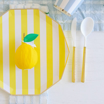 Yellow and white striped placemat with a lemon design on a table setting.