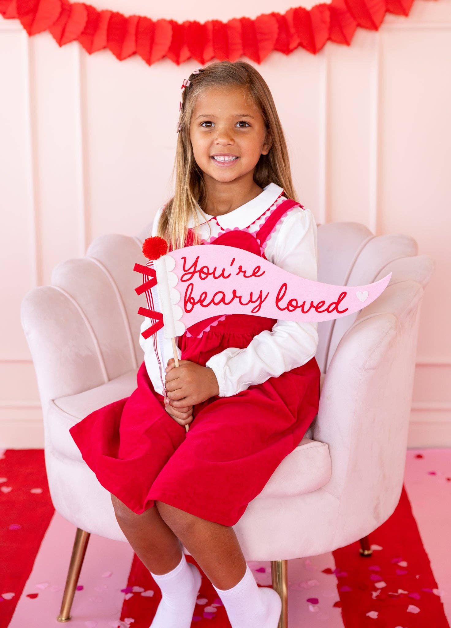 Child holding You’re Beary Loved felt pennant for Valentine’s Day decor 