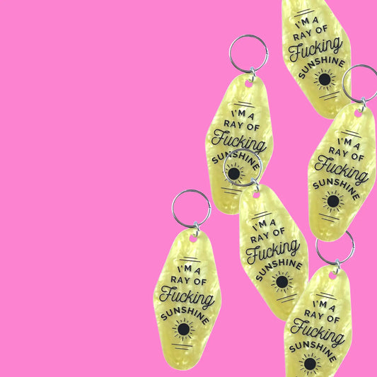 yellow keychain with "i'm a ray of fucking sunshine" engraved