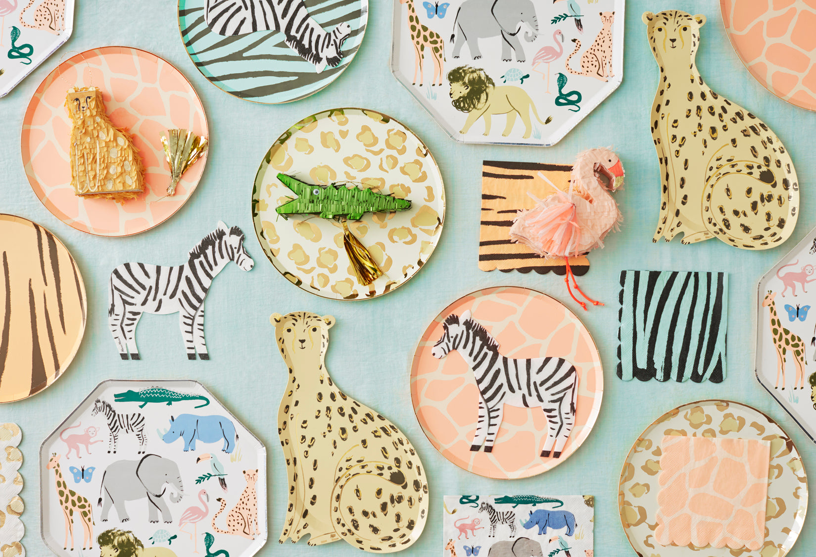 Jungle-inspired tablescape featuring zebra napkin and matching safari animal partyware.