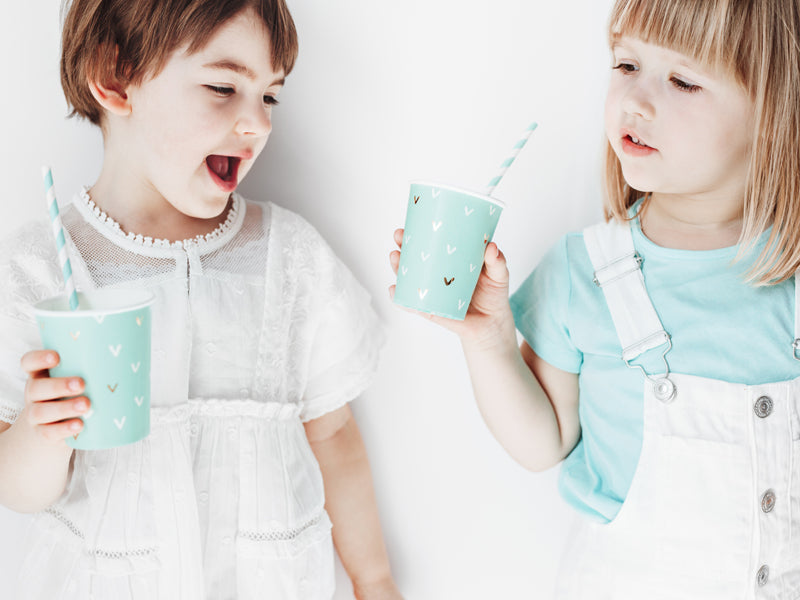 young children holding cups with blue and white striped paper straws