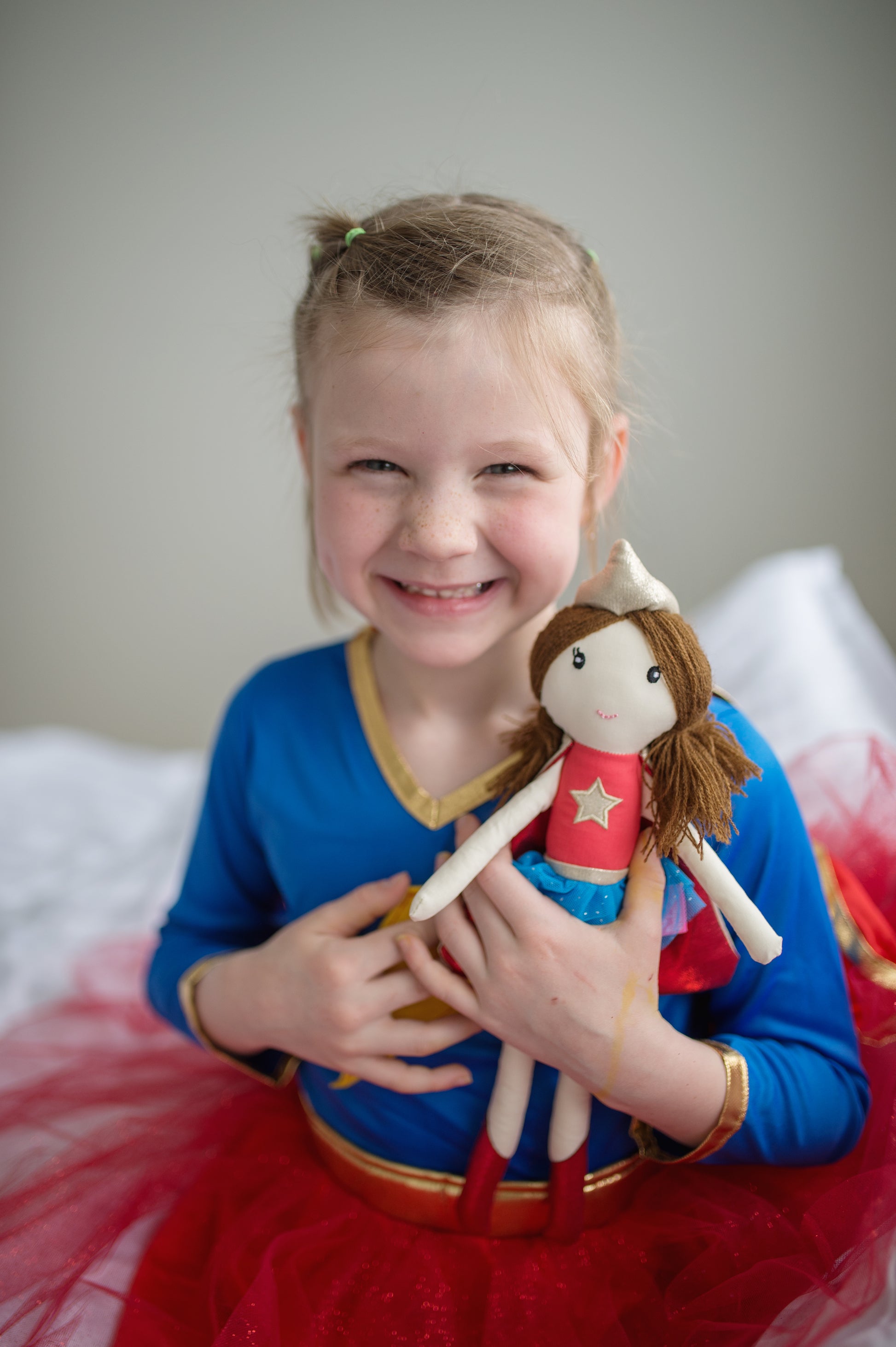 young girl hugging suzie the supergirl doll